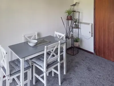 a table and chairs in a room with a refrigerator at Strawberry Hill in Hayle