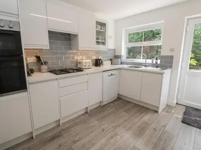 a kitchen with white cabinets and a sink at Jaluna in St Ives