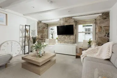 a living room with a couch and a tv at Charming Cottage by the Sea, Wi-Fi, Pets in St Ives