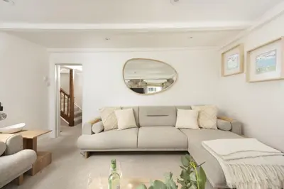 a living room with a couch and a mirror at Charming Cottage by the Sea, Wi-Fi, Pets in St Ives
