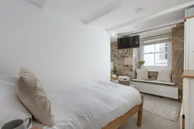 a bedroom with a white bed and a window at Charming Cottage by the Sea, Wi-Fi, Pets in St Ives