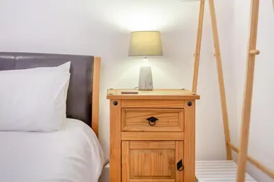 a bed with a night stand with a lamp on it at 2 Bed in Fowey oc-s25324 in Fowey