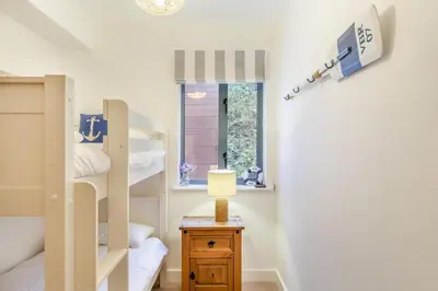 a bedroom with bunk beds and a table with a lamp at 2 Bed in Fowey oc-s25324 in Fowey
