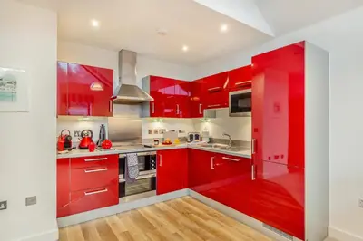 a red kitchen with white walls and wooden floors at 2 Bed in Fowey oc-s25324 in Fowey