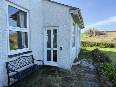 a bench sitting outside of a house with a door at 1 The Links in St Ives