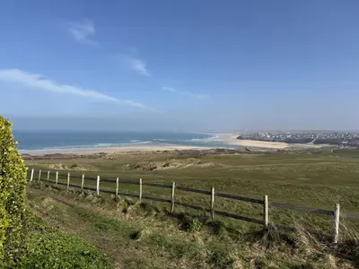 a fence on a hill with the ocean in the background at 1 The Links in St Ives
