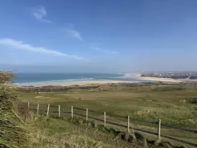 a view of the ocean from a hill with a fence at 1 The Links in St Ives