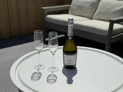 a bottle of wine and two wine glasses on a table at 5 Ayr Court in St Ives