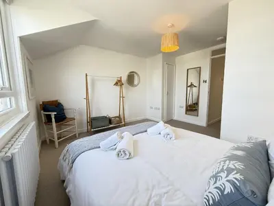 a bedroom with a white bed with towels on it at 5 Ayr Court in St Ives