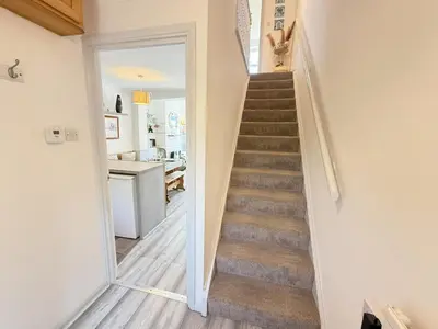 a staircase in a home with a hallway and a kitchen at Gwel an Mor in St Ives