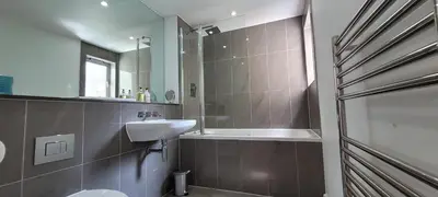 a bathroom with a toilet and a sink and a shower at 4 Fistral Beach Apartments, Newquay, TR7 1FR in Crantock