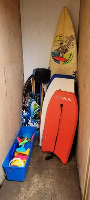 a surfboard and a box next to a surfboard at 4 Fistral Beach Apartments, Newquay, TR7 1FR in Crantock