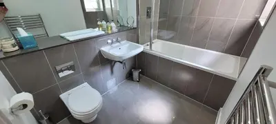 a bathroom with a toilet and a tub and a sink at 4 Fistral Beach Apartments, Newquay, TR7 1FR in Crantock