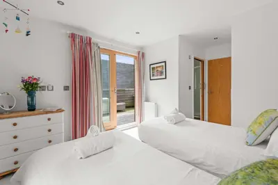 a bedroom with two beds and a window at House 19 in Looe