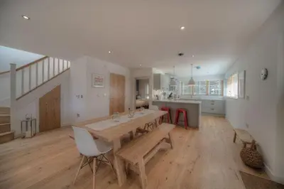 a large kitchen with a wooden table and chairs at House 21 in Looe