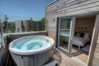 a jacuzzi tub on a balcony with a bedroom at House 21 in Looe