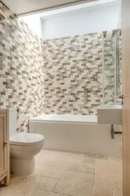 a bathroom with a toilet and a tub and a sink at House 2 in Looe