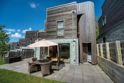a house with a patio with a table and an umbrella at House 2 in Looe