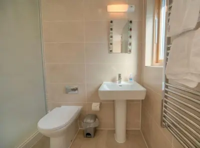 a bathroom with a toilet and a sink at House 26 in Looe