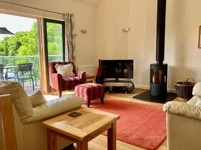 a living room with a fireplace and a tv at House 26 in Looe