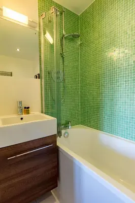 a bathroom with a tub and a sink and a shower at House 28 in Looe