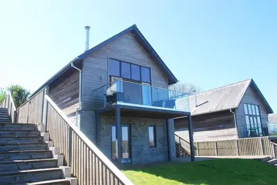 a house with a glass balcony on the side of it at House 28 in Looe
