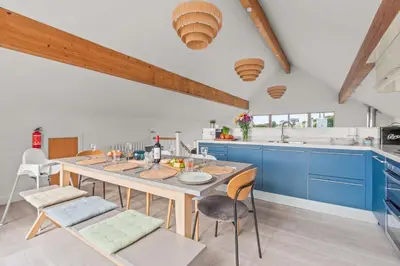 a kitchen with blue cabinets and a table and chairs at House 27 in Looe