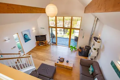an open living room with a couch and a tv at House 27 in Looe