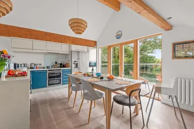 a kitchen with a dining room table and chairs at House 27 in Looe