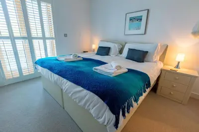a bedroom with a large bed with towels on it at House 27 in Looe