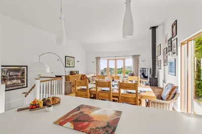 a dining room and living room with white walls at House 25 in Looe
