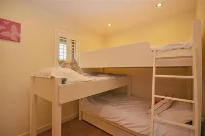 a bedroom with two bunk beds and a window at House 29 in Looe