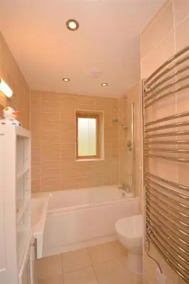 a bathroom with a tub and a toilet and a sink at House 29 in Looe