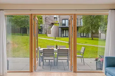 an open patio door with a table and chairs at House 3 in Looe