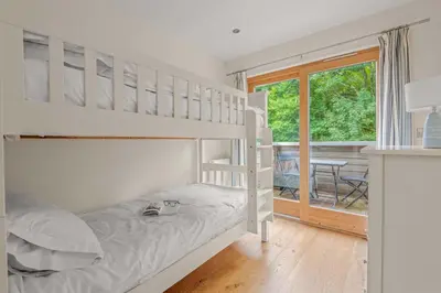 a bedroom with a bunk bed and a balcony at House 3 in Looe