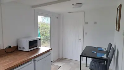 a kitchen with a table with a microwave on a counter at D21 Treville, Riviere Towans in Hayle