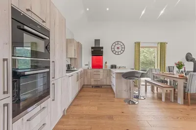 a kitchen with white cabinets and a red refrigerator at House 24 in Talland