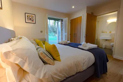 a bedroom with a large white bed with yellow pillows at House 30 in Looe