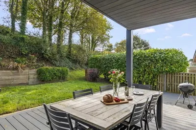 a wooden table with chairs on a deck at House 31 in Looe