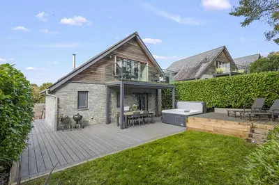 a backyard with a wooden deck and a house at House 31 in Looe