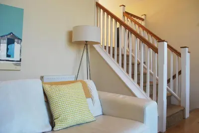 a living room with a white couch and stairs at House 32 in Looe