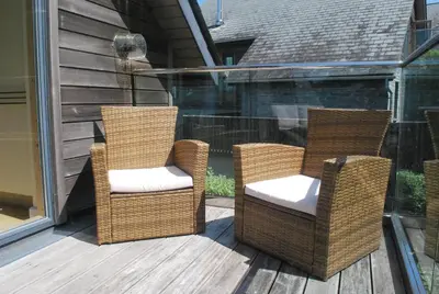 three wicker chairs sitting on a porch at House 32 in Looe