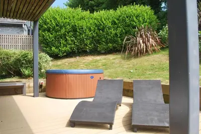 two chairs and a trash can on a patio at House 32 in Looe