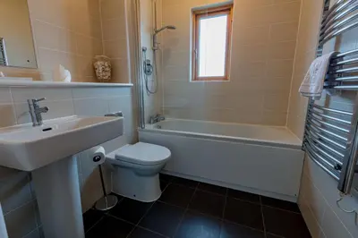 a bathroom with a sink and a toilet and a tub at House 37 in Looe