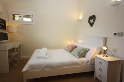 a bedroom with a bed and a desk and a television at House 37 in Looe