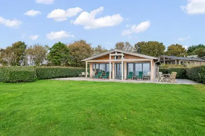 a house with a green lawn in front of it at House 39 in Looe
