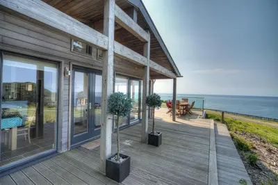 a house with two potted trees on a deck at House 38 in Looe