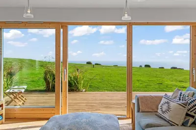 a living room with a large sliding glass door at House 40 in Looe