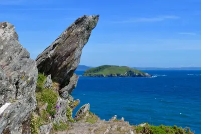 a large rock in the ocean with an island in the background at House 41 in Looe