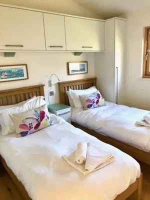 a room with two beds with towels on them at House 41 in Looe